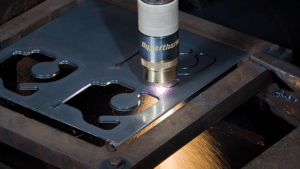 Processo de corte plasma CNC de alta precisão em chapa de aço carbono na Gans, mostrando a tocha em operação e faíscas metálicas.